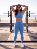 Talea wearing Coastal Blue Full Brand high-waisted leggings, front view with white FF logo