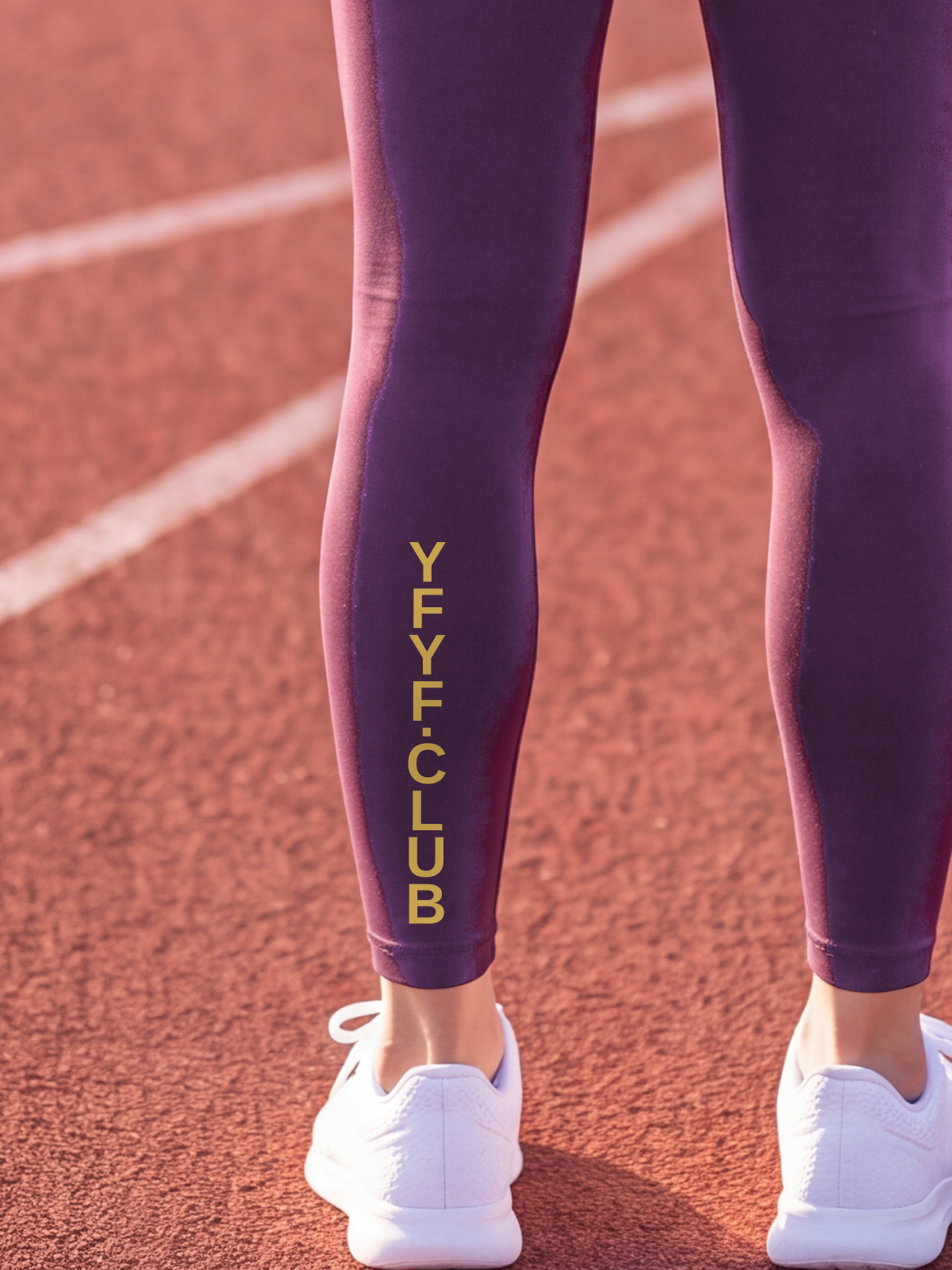 Close-up of the gold YFYF.CLUB print on the calf of the Purple Full Brand leggings
