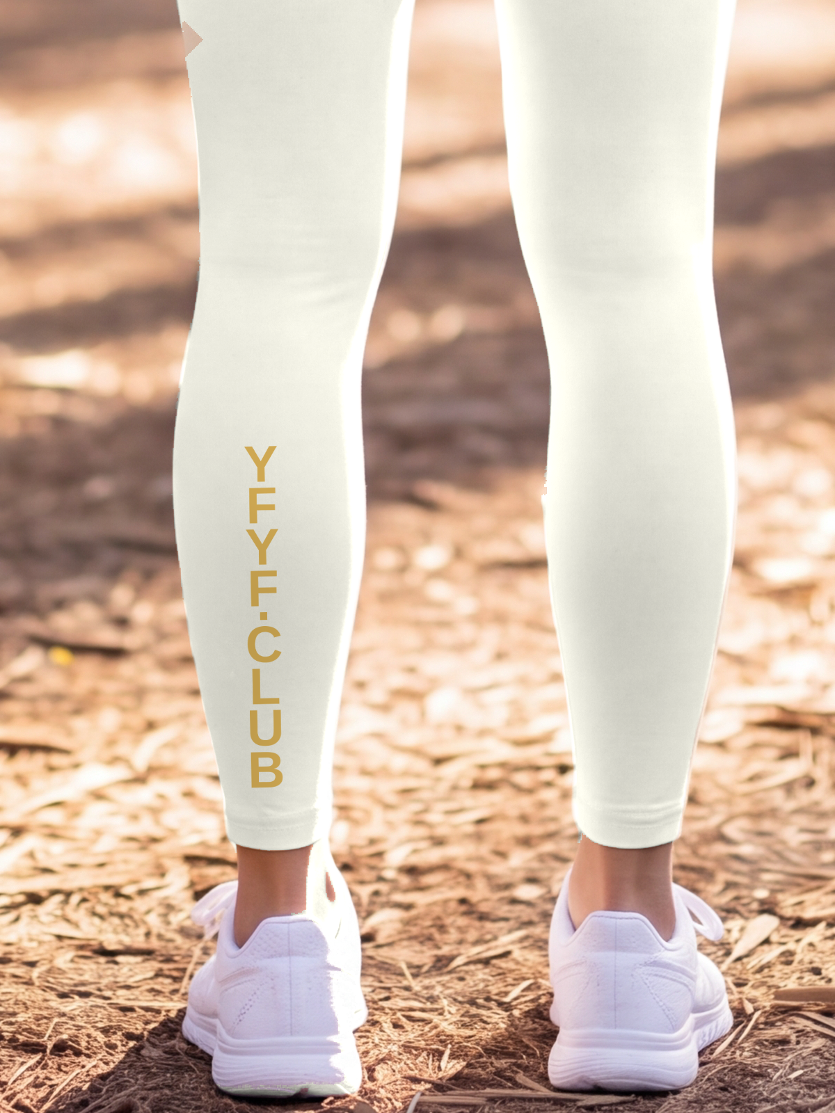 Close-up of the gold YFYF.CLUB print on the calf of the Beige Full Brand leggings
