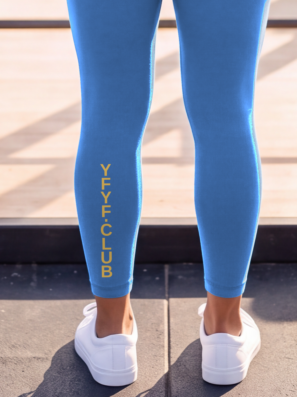 Close-up of the gold YFYF.CLUB print on the calf of the Coastal Blue Full Brand leggings
