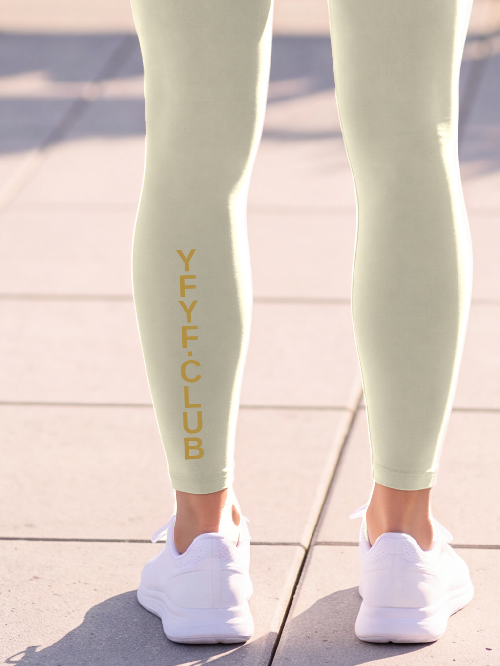 Close-up of the gold YFYF.CLUB print on the calf of the Light Gray Full Brand leggings