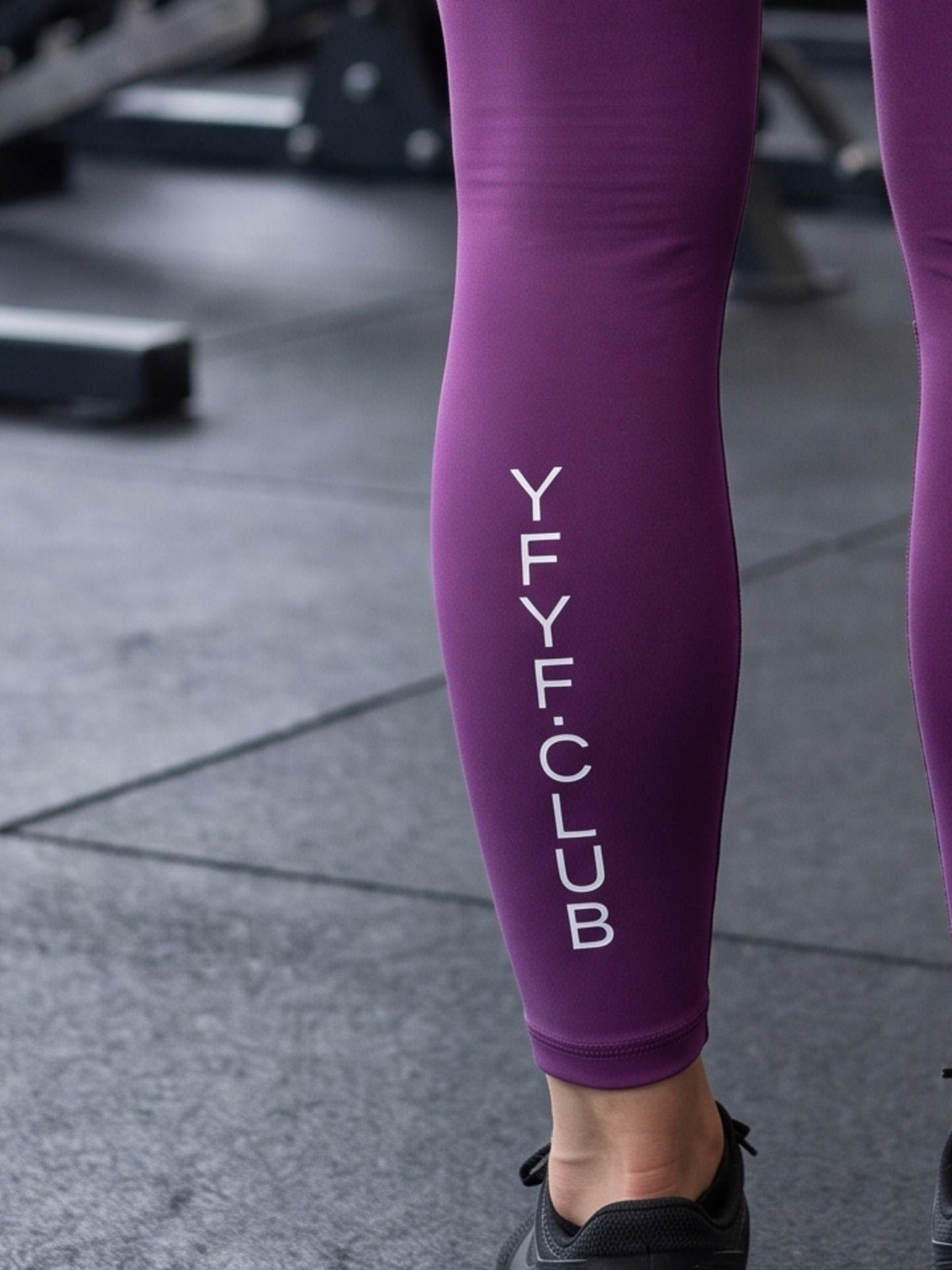 Close-up of YFYF.CLUB printed on the calf of the Purple White Logo leggings