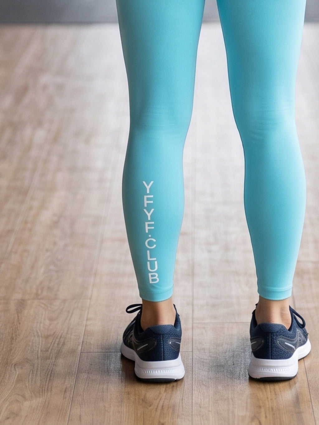 Close-up of YFYF.CLUB printed on the calf of the Lake Blue White Logo leggings