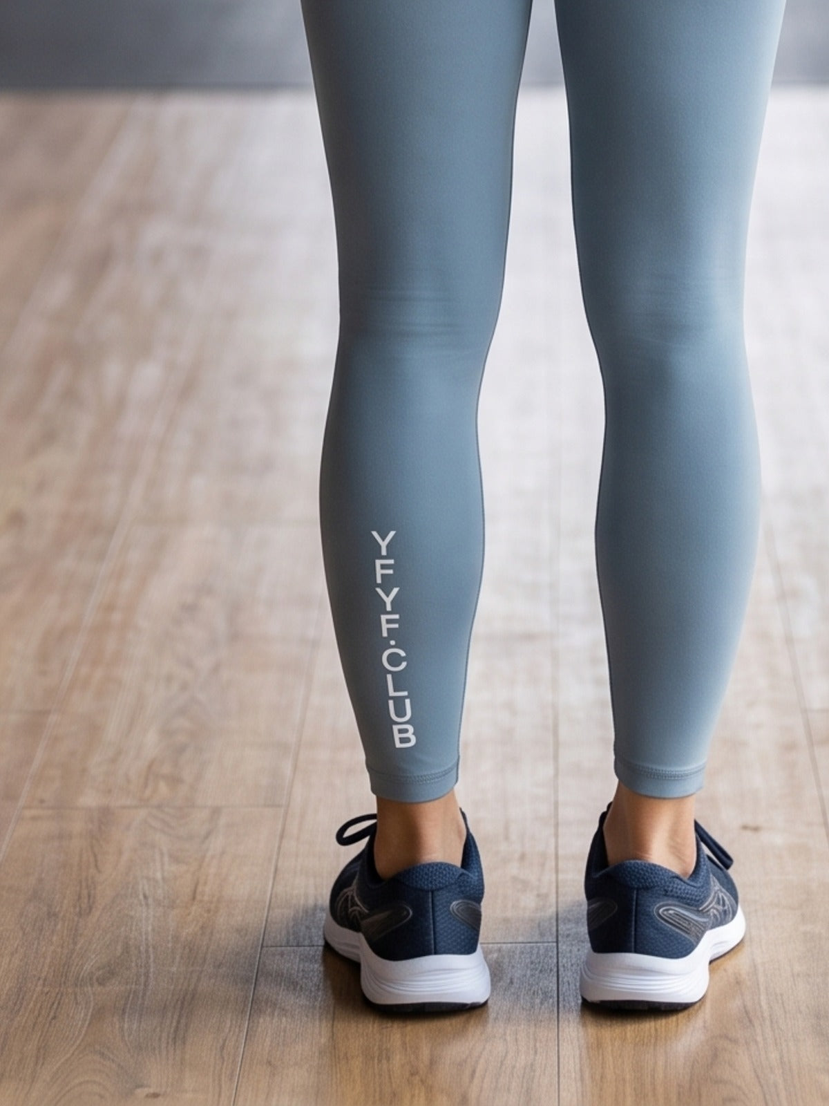 Close-up of YFYF.CLUB printed on the calf of the Mist Blue White Logo leggings