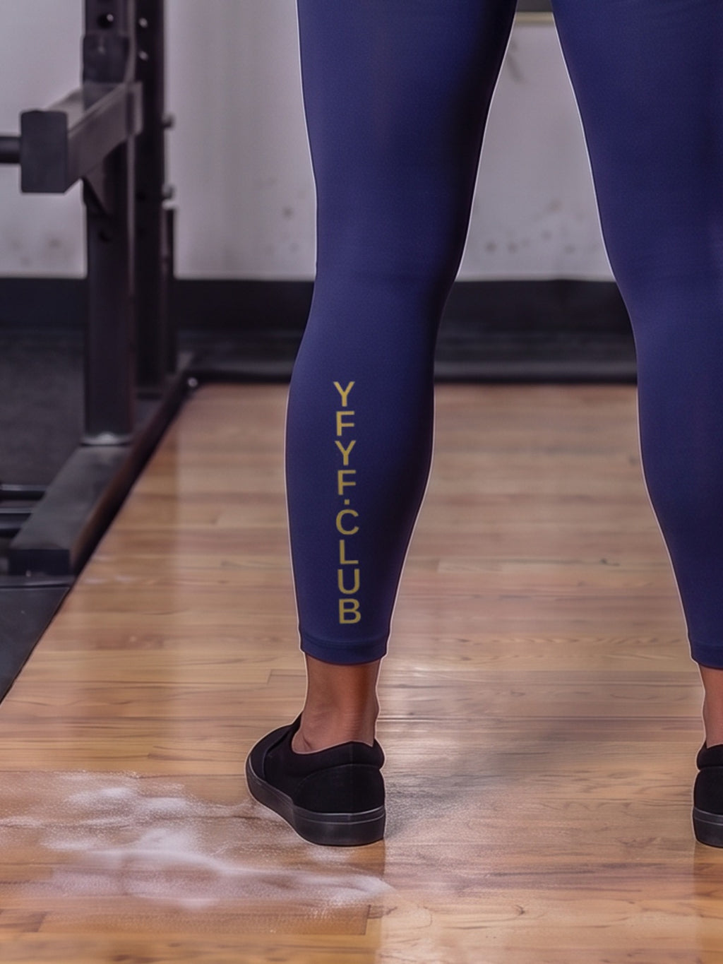 Close-up of gold YFYF.CLUB printed on the calf of the Royal Blue Gold Logo leggings