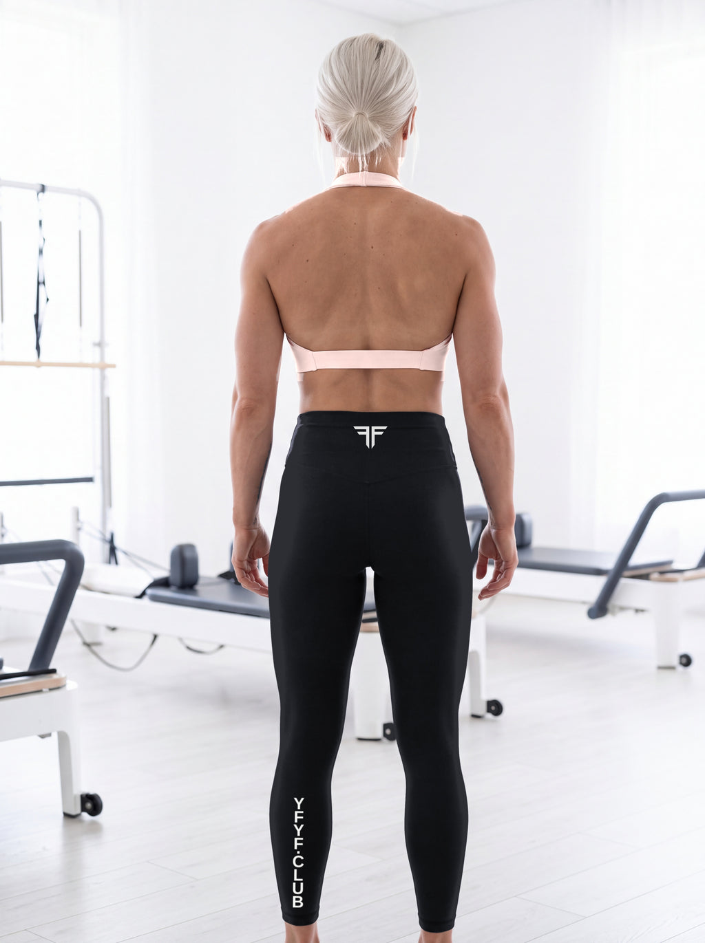 Katya wearing the YFYF Pink Pleated Halter Sports Bra, back view showing the halter neck and open back