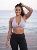 Elkie wearing the YFYF Purple (lilac) Pleated Halter Sports Bra, front view with silver FF logo on the left chest